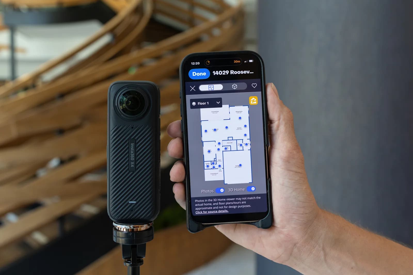 360-degree camera beside a phone displaying the captured property floor plan